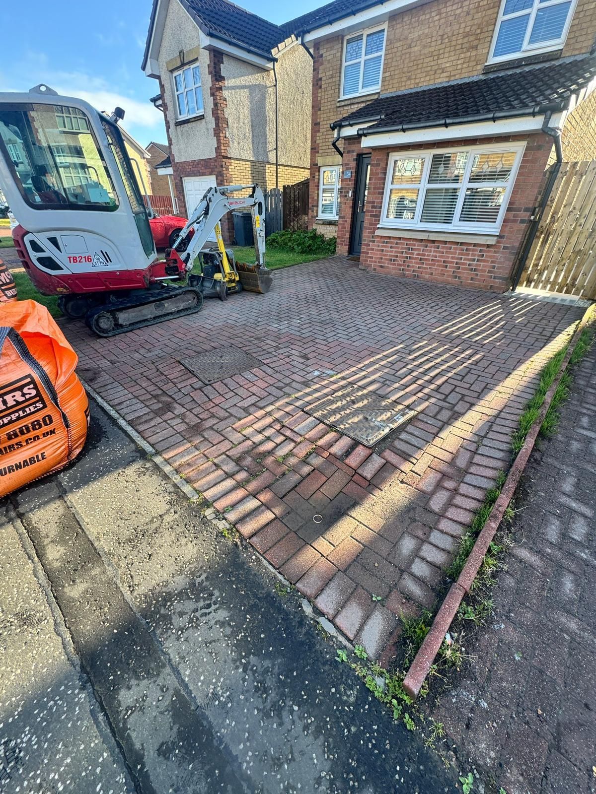 Before image of an uneven Glasgow front garden and tired driveway area before monoblock driveway installation