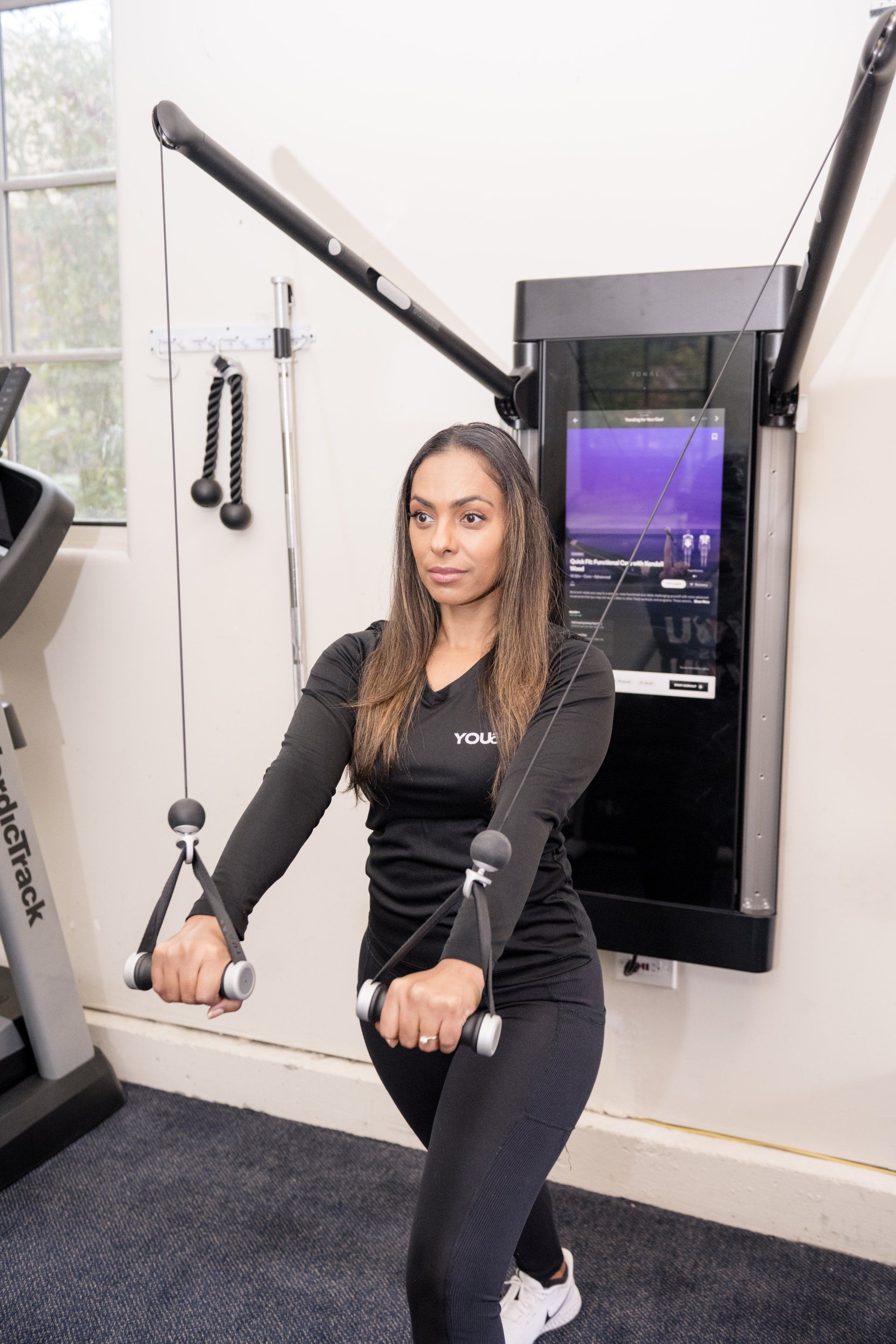 A woman is using a machine in a gym.