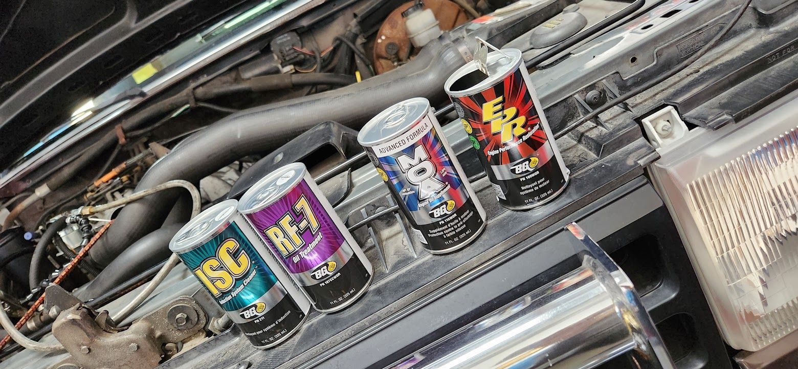 A row of cans sitting on top of a car engine.