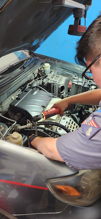 A man is working on the engine of a car - Sean's Auto Care