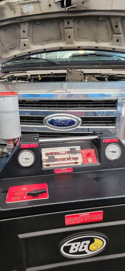 A garage with cars on lifts and a sign that says sean 's auto care - Sean's Auto Care