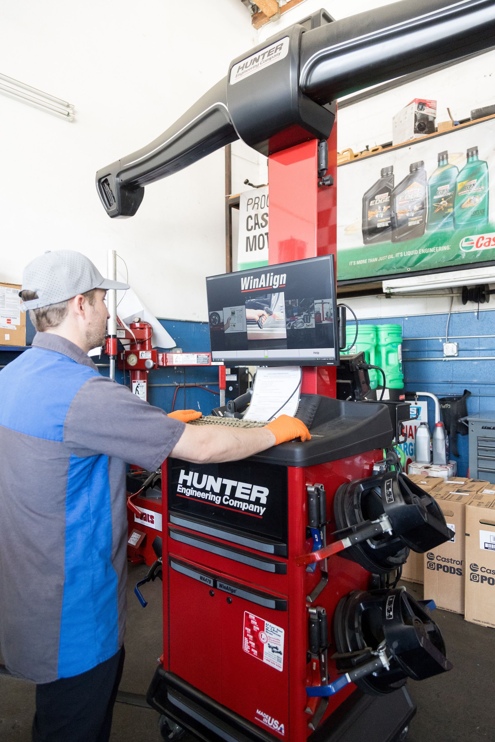 Technician operating a red Hunter tire alignment machine in an auto repair shop | Sean's Auto Care