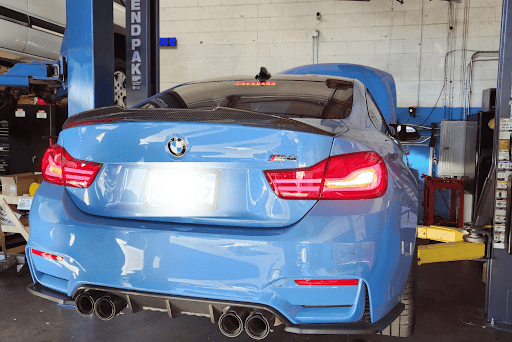 Top 5 BMW repair issues in Van Nuys, CA Los Angeles Area with Sean’t Auto Care - BMW Repair Specialists. Image of the rear of newer BMW vehicle on a lift in the shop for BMW maintenance and repair services.