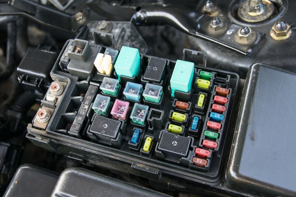 Road Trip Vehicle Prep - Essential Electrical System Checks | Sean's Auto Care. Closeup image of car electrical system with fuses.
