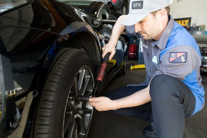 Two men are working on a car with the hood open - Sean's Auto Care