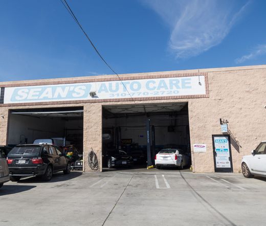 Sean’s Auto Care garage with cars parked in open service bays under a bright sky | Sean's Auto Care