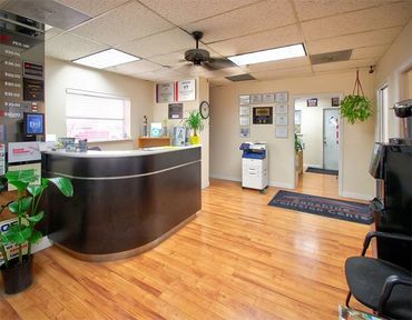 A reception area with a black counter and a ceiling fan
