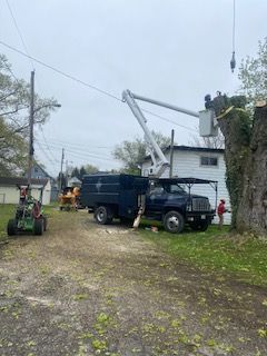 A truck with a crane on top of it is parked in front of a house.