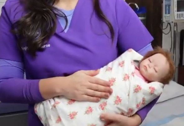 Technician demonstrating holding a baby