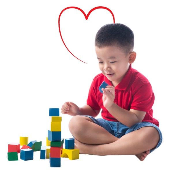 A young boy in a red shirt is playing with wooden blocks