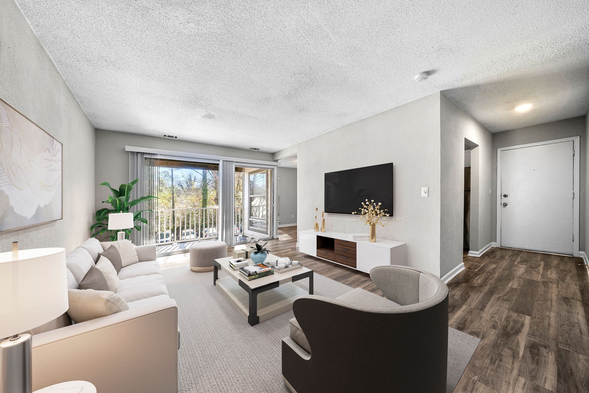 Bright modern living room with sofa, coffee table, TV, and sliding doors to a balcony.