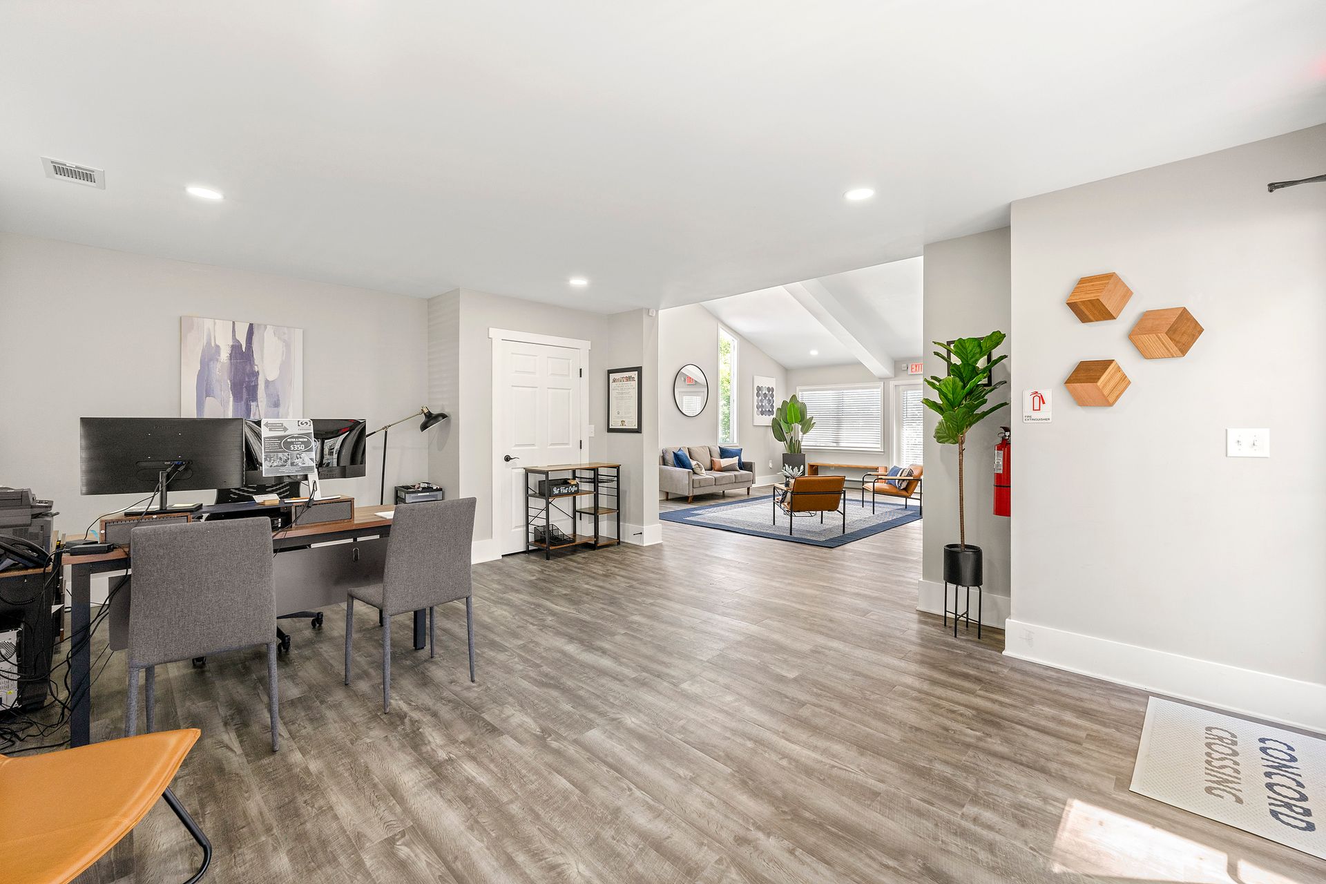 Open-plan living and dining room with gray floors, modern furniture, and white walls