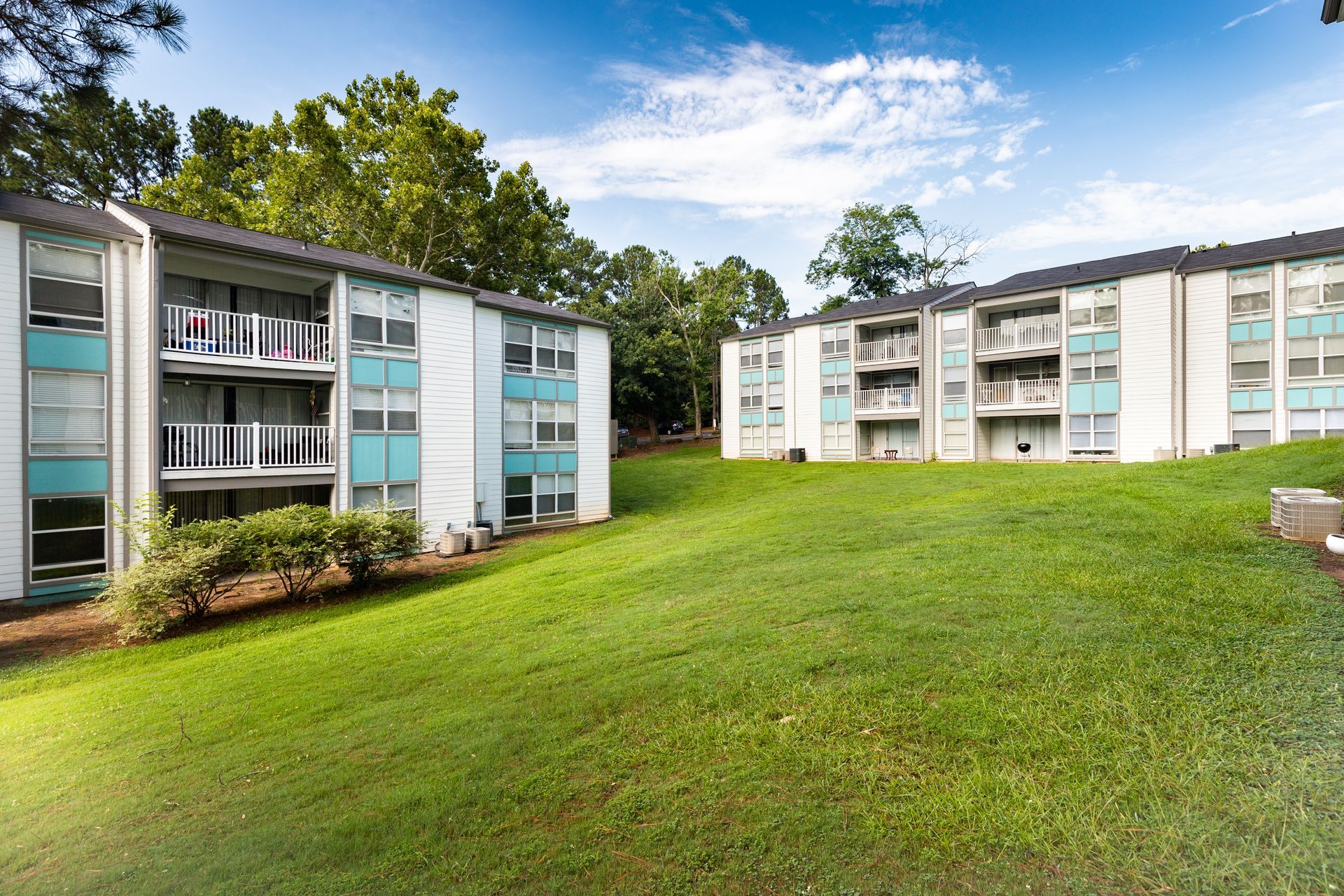 Apartment buildings around a grassy courtyard under a blue sky