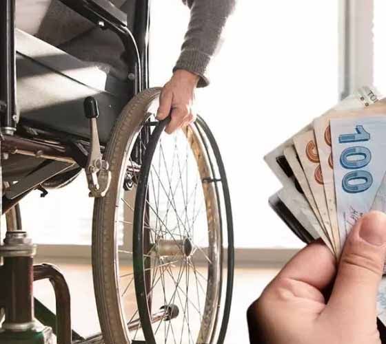 A person in a wheelchair is holding a handful of money.