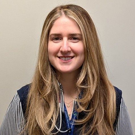 Head-and-shoulders profile photo of Dr. Tiffany Hecht, MD, Pediatrician wearing a striped button-down shirt under a dark vest and a stethoscope, photographed against a plain light-colored background.
