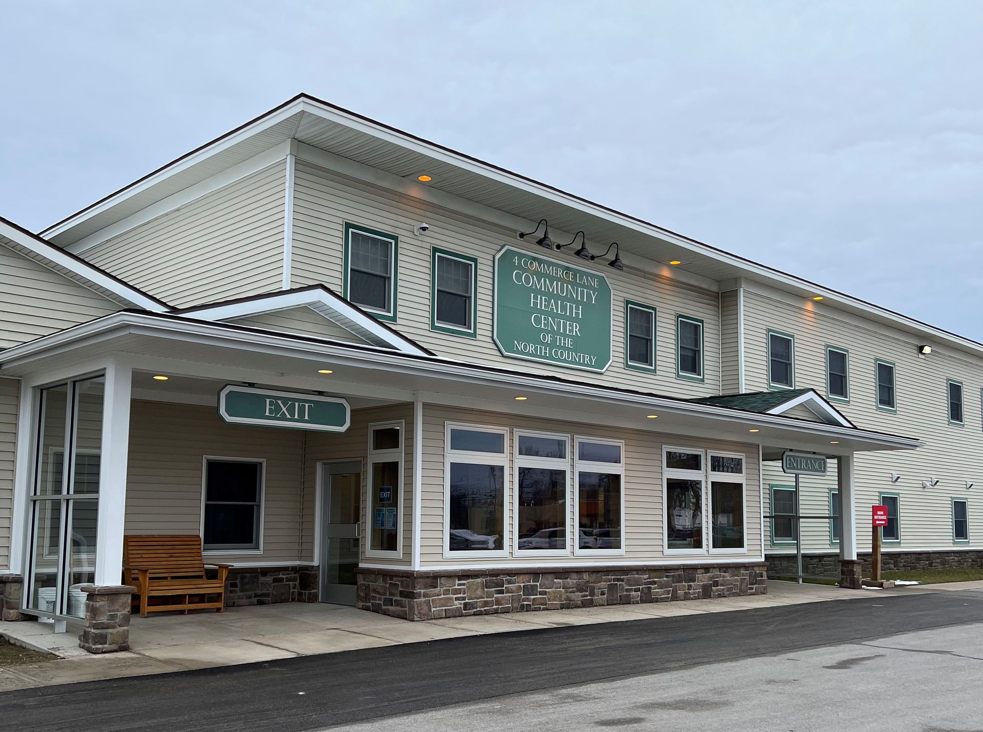 Exterior view of the Community Health Center of the North Country building in Canton with a covered entrance, large windows, and visible entrance and exit signs.