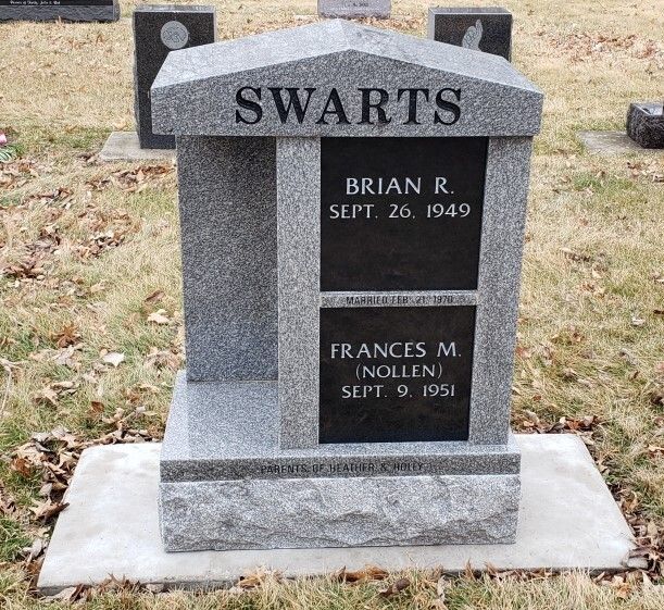 A grey granite tombstone in a cemetery with the family name