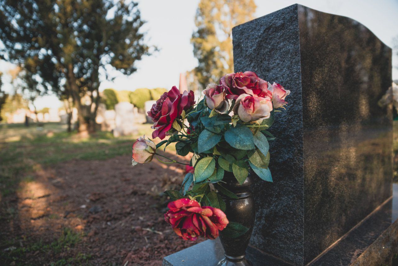 Close-up of red roses placed on a gravestone at a cemetery memorial service in Philadelphia, PA