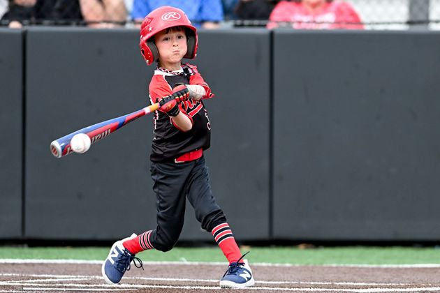 Baseball player sliding into home plate, catcher in front. Blue and gold uniforms, action shot.