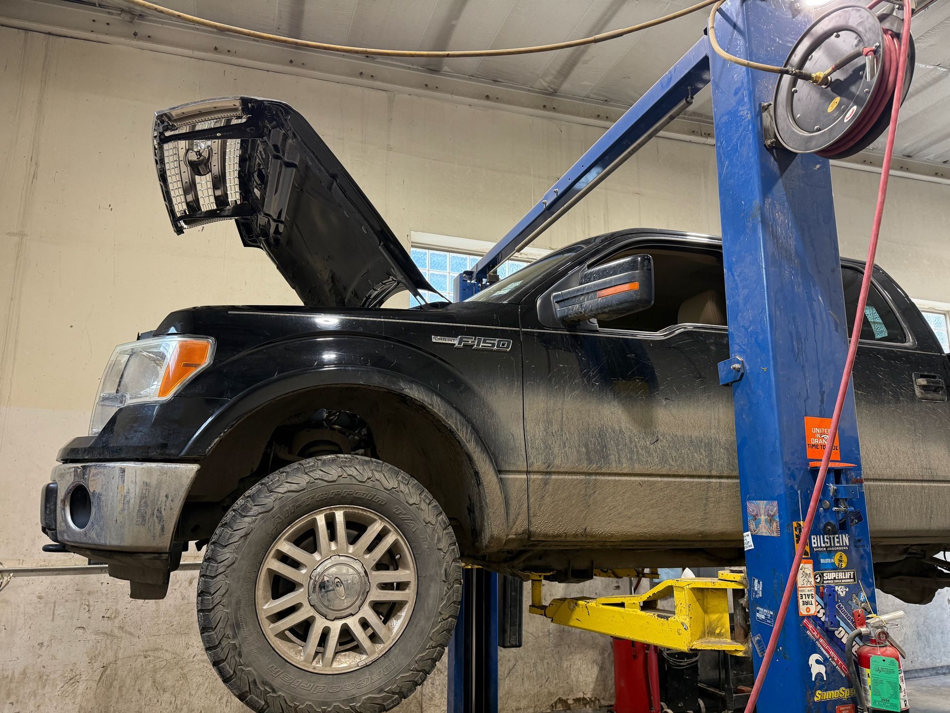 Technician inspecting a vehicle transmission on a lift