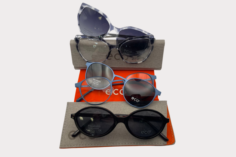 Four pairs of eyeglasses in blue, black, brown, and silver on a white surface