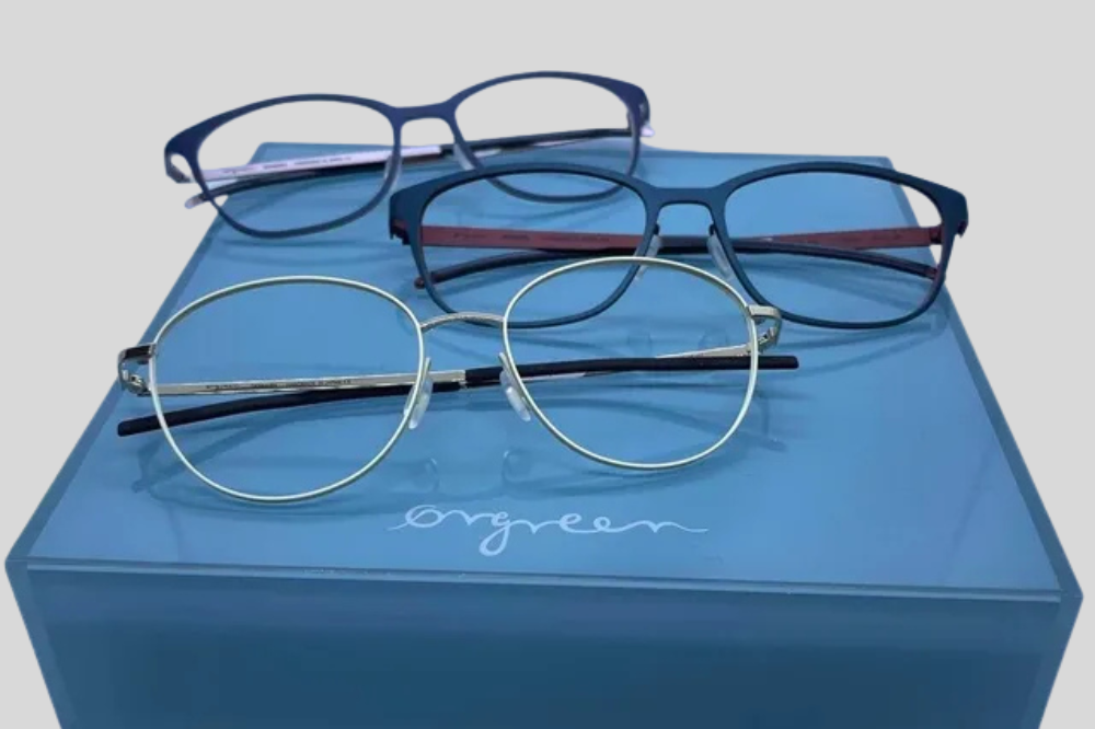Four eyeglass frames on a blue box against a light blue background
