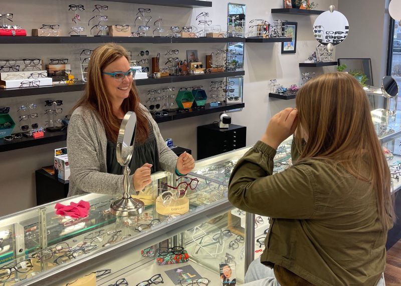 Customer speaking with a clerk at a jewelry display counter in a bright boutique.