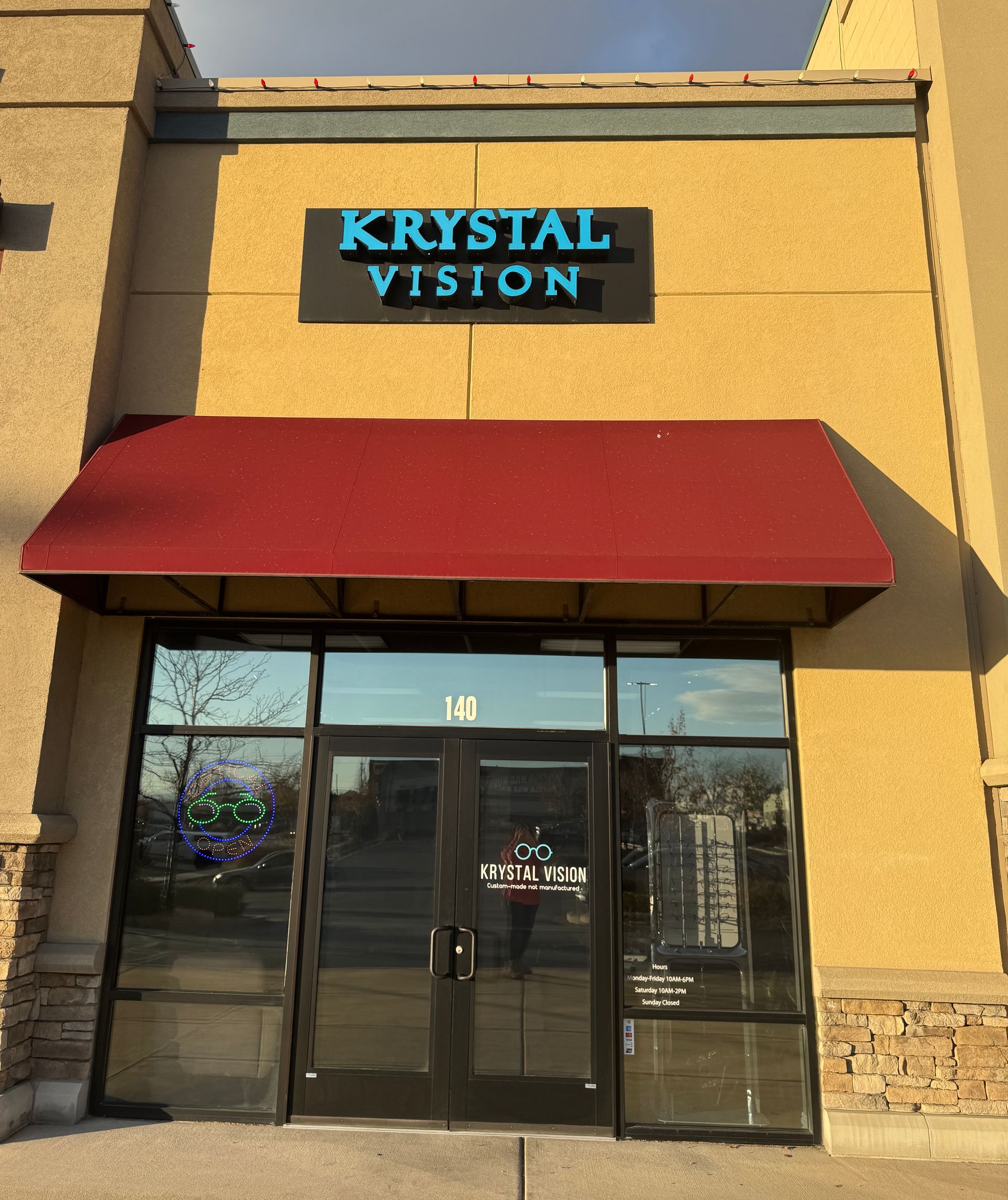 Person trying on eyeglass frames in an optical store display