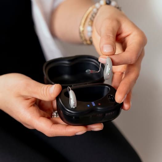 Hands Holding an Open Black Charging Case — Local Hearing Aid Specialists in Wallsend, NSW