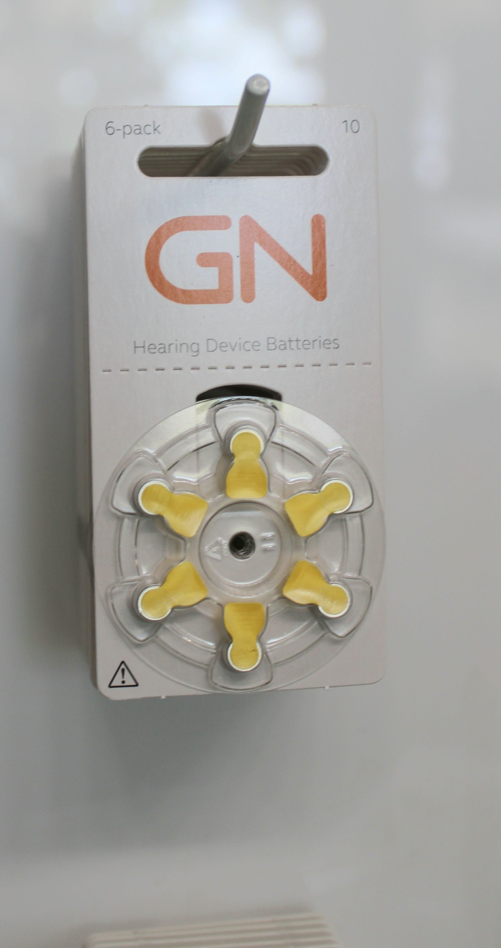 Yellow and gray GN fidget spinner toy in retail packaging hanging on display — Local Hearing Aid Specialists in Wallsend, NSW
