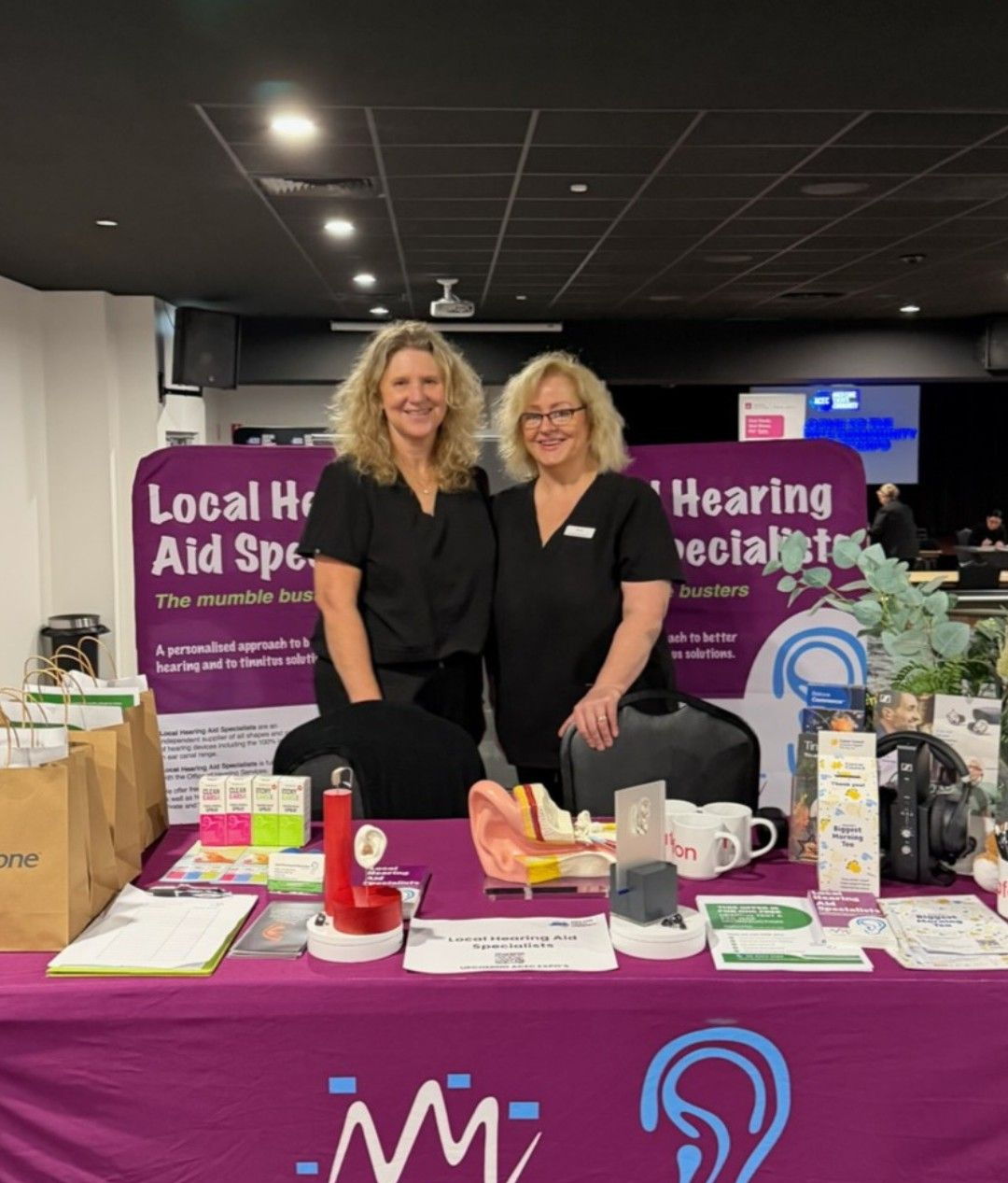 Two Women at a Hearing Health Booth — Local Hearing Aid Specialists in Wallsend, NSW