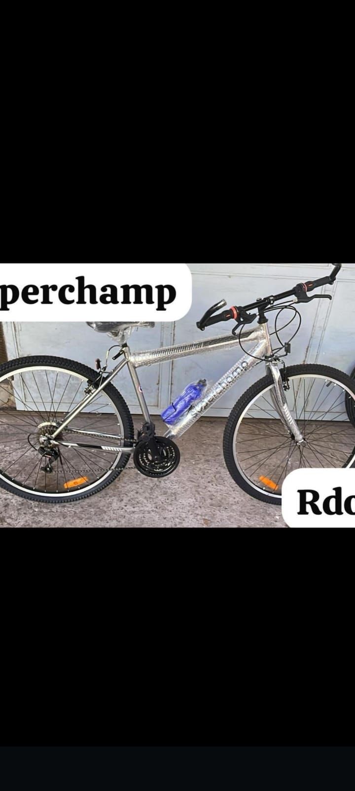 Bicicleta de montaña con llantas amarillas sobre tierra, con las etiquetas “Superchamp” y “Rdo29”.