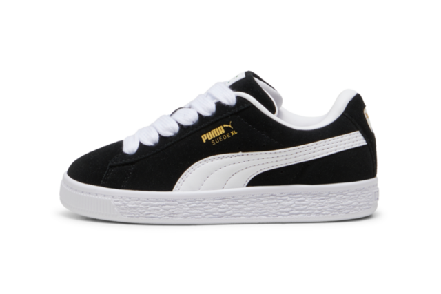 Zapatillas Puma Suede blancas y negras con cordones y suela blancos. Logotipo de Puma dorado en el lateral.