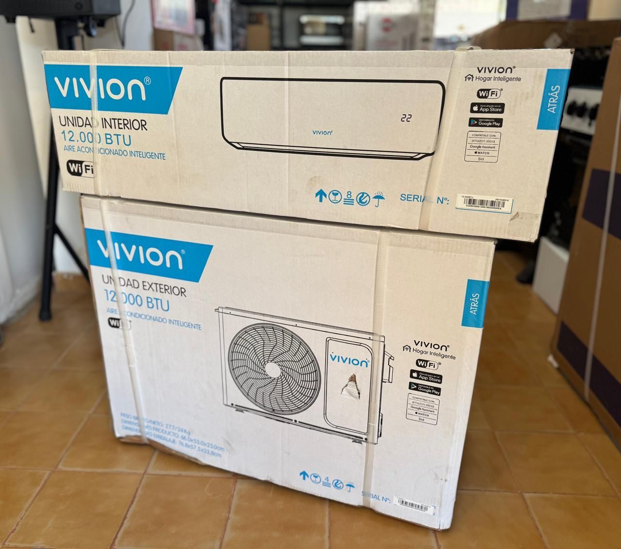 Dos cajas de ventiladores Vivion apiladas sobre un suelo de baldosas en el interior de una tienda o vivienda.