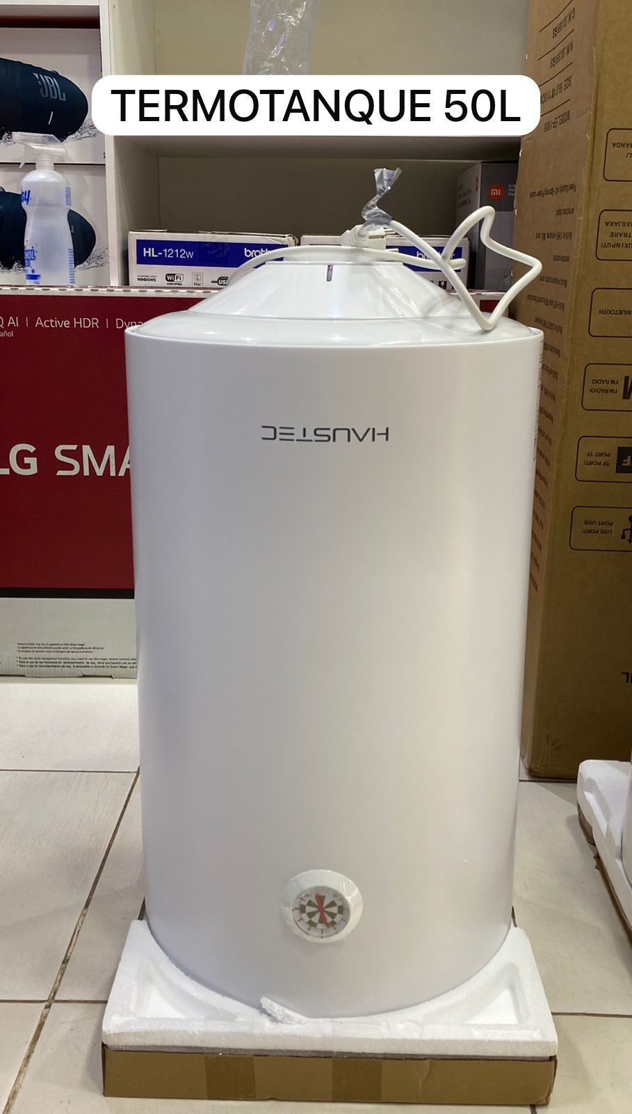 Calentador de agua cilíndrico blanco de 50 litros expuesto en una tienda, con un mando de control de temperatura en la base.