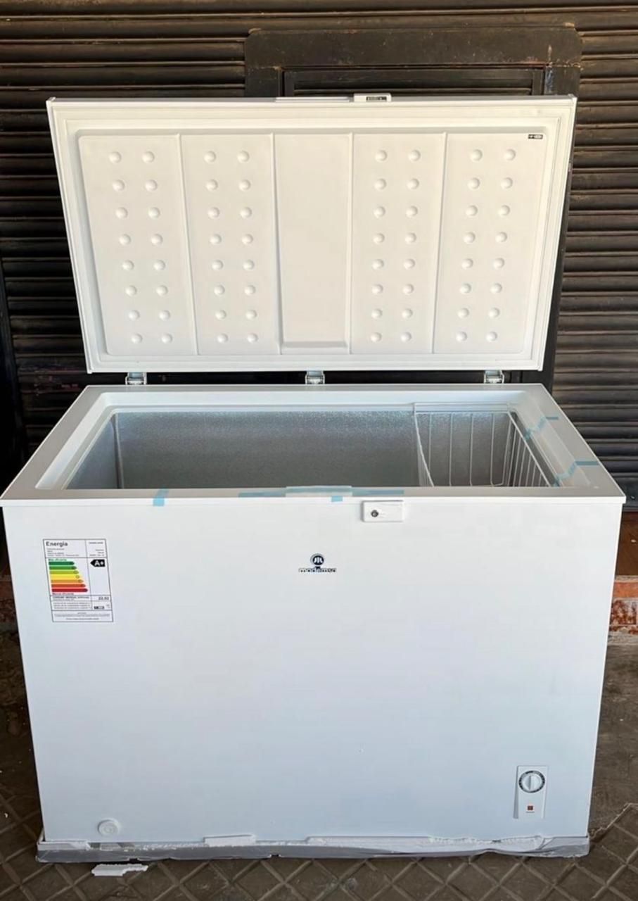Congelador horizontal blanco con la tapa abierta, que deja ver su interior vacío contra una pared oscura.