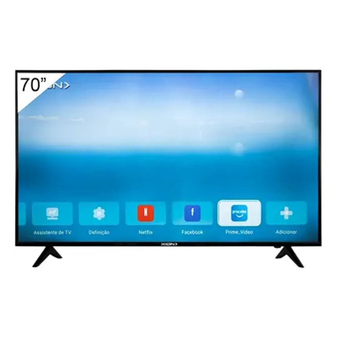 Televisor de pantalla plana sobre soporte con pantalla de inicio azul e iconos de aplicaciones, mostrando una etiqueta de 70 pulgadas en la esquina.