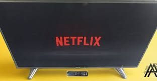 Logotipo de Netflix en una pantalla de televisión negra con fondo amarillo.