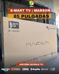 Caja de TV Marson de 85 pulgadas, color blanco, en una tienda con letrero “Smart TV” y “Sistema Google TV”