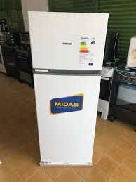Mininevera blanca de la marca Midas en el pasillo de una tienda con una etiqueta energética en la puerta.