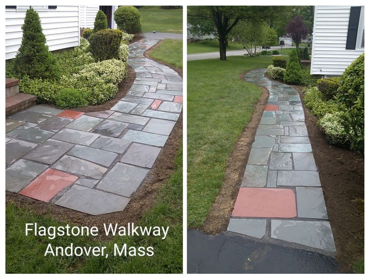 Stone walkway beside a white house, showing uneven slate pavers with patch repairs in a landscaped yard.