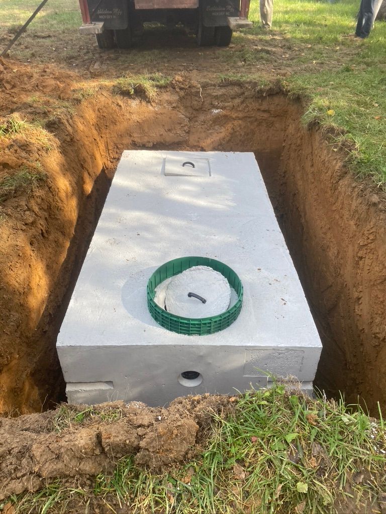 Septic tank being installed in an excavated pit.