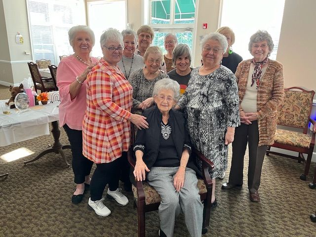 A group of older women are posing for a picture in a room.