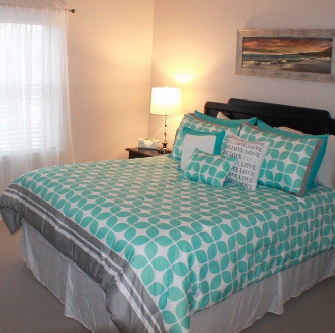 A bed with a polka dot comforter and pillows that say