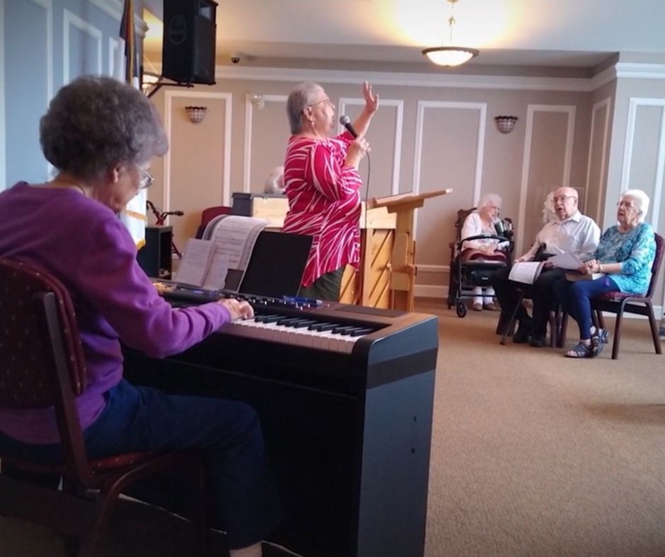 A woman is playing a keyboard in front of a group of people