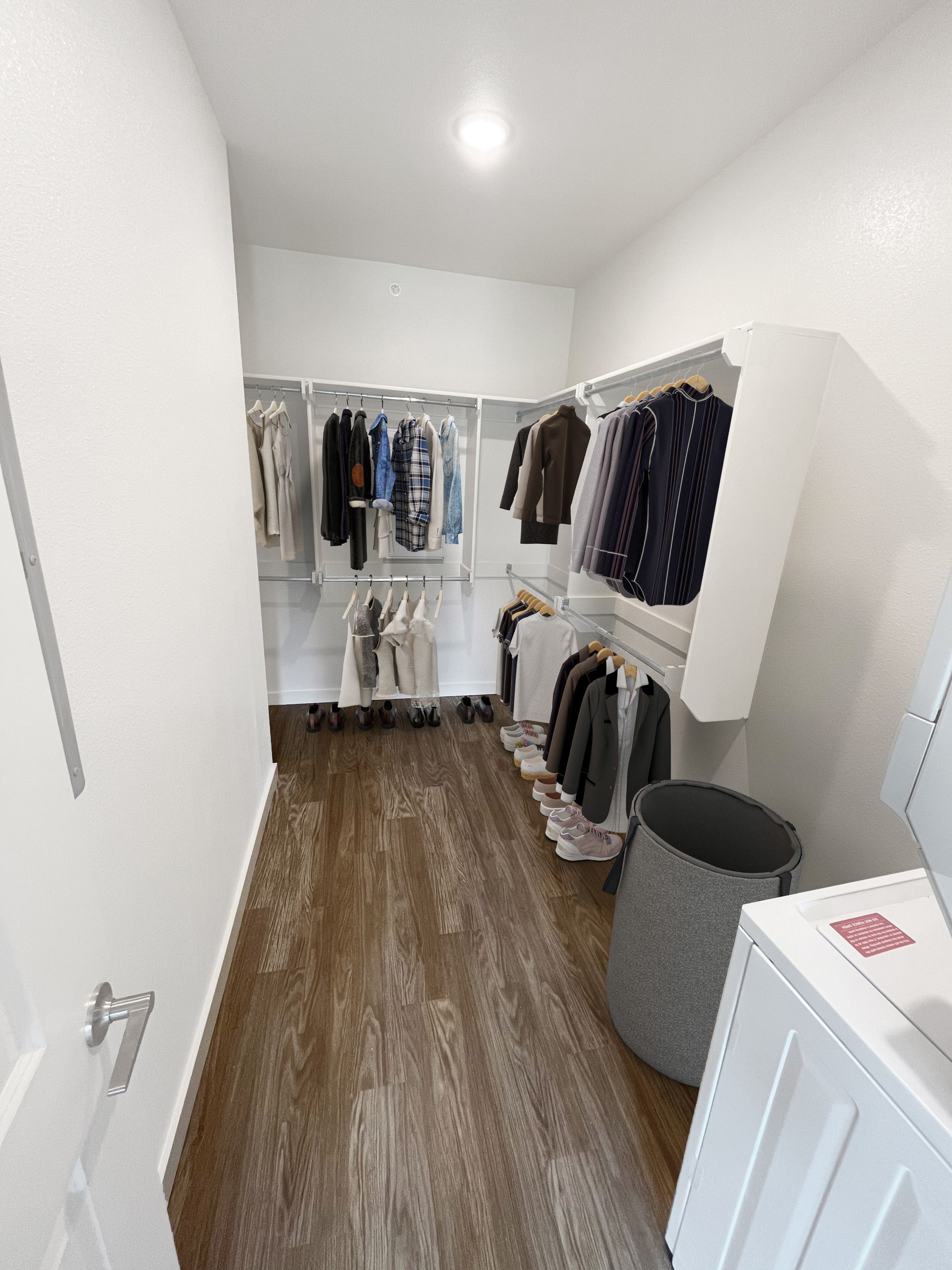 A walk in closet with a washer and dryer in it.