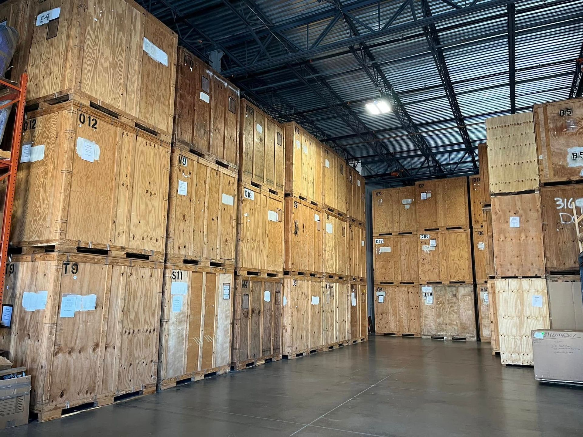 Wooden storage crates stacked high in a warehouse setting.