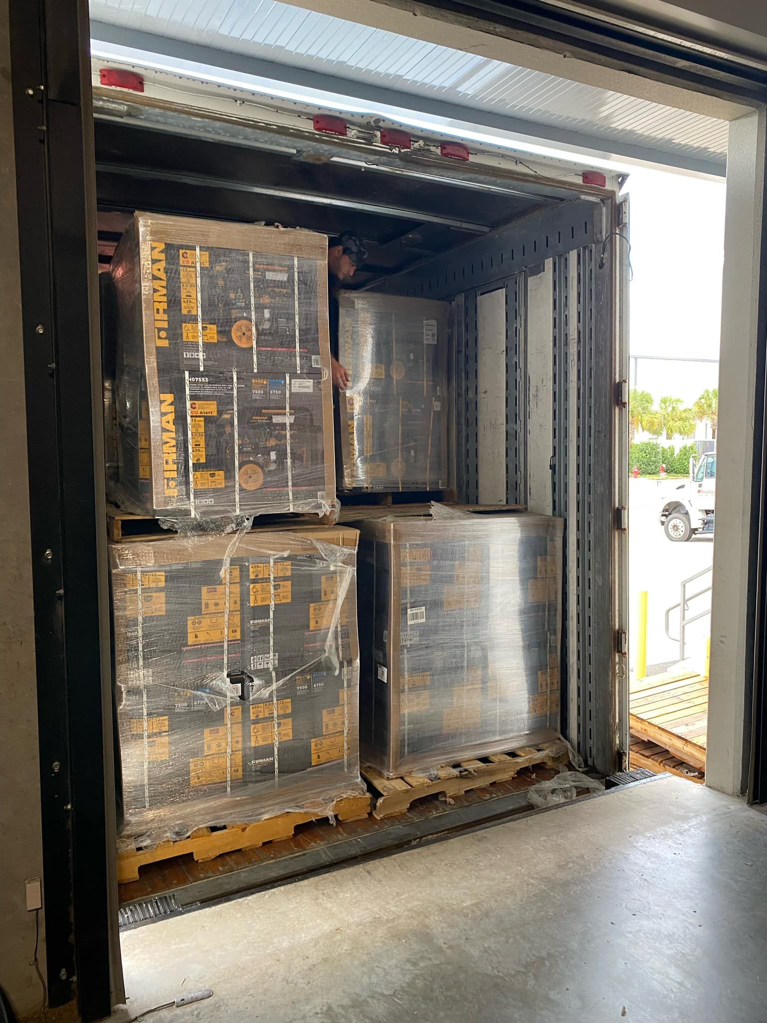 Pallets of wrapped items inside a loading dock, ready for transport.