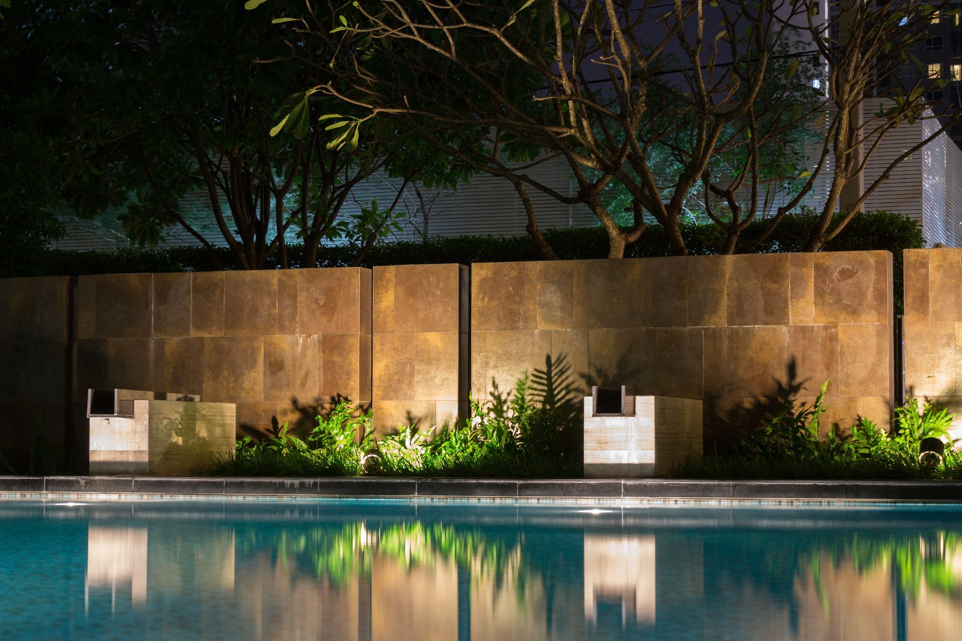 A large swimming pool is lit up at night