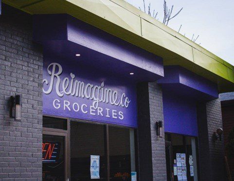 The front a grocery store; the sign is purple and says